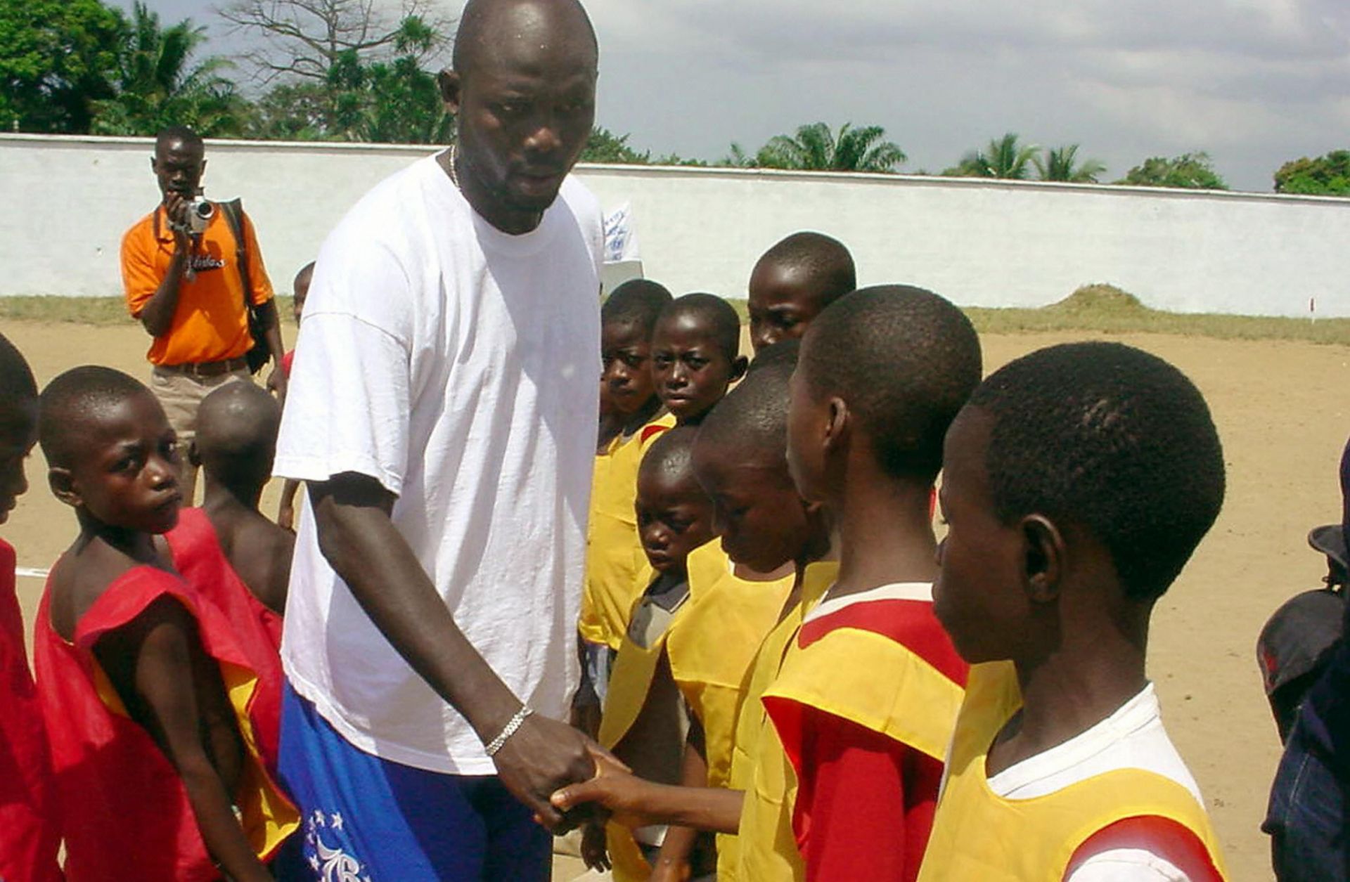 Liberia's star soccer player turned politician George Weah shakes hands with former children soldiers in Monrovia.