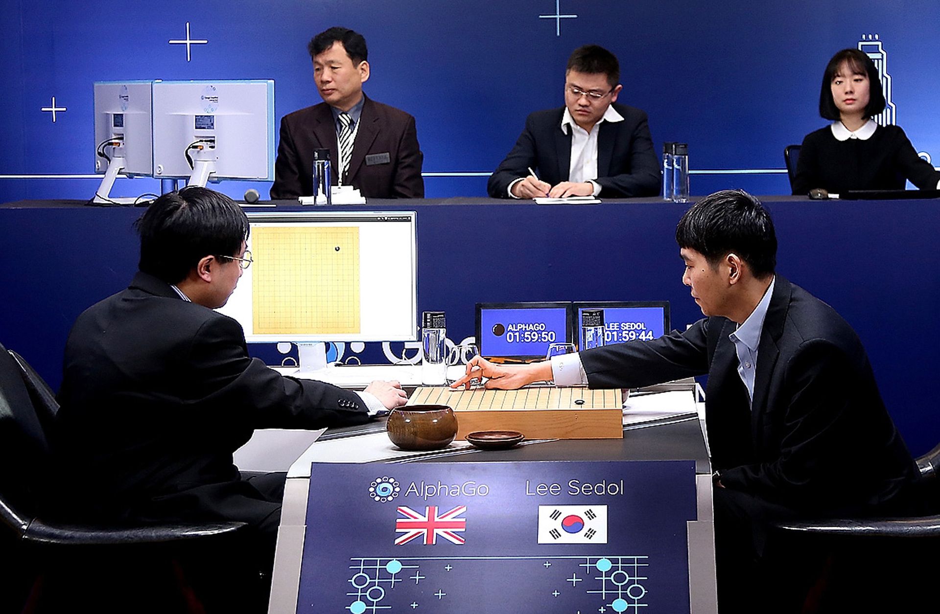 South Korean professional Go player Lee Sedol (R) puts his first stone in a match against Google artificial intelligence program AlphaGo, which eventually won four of five games.
