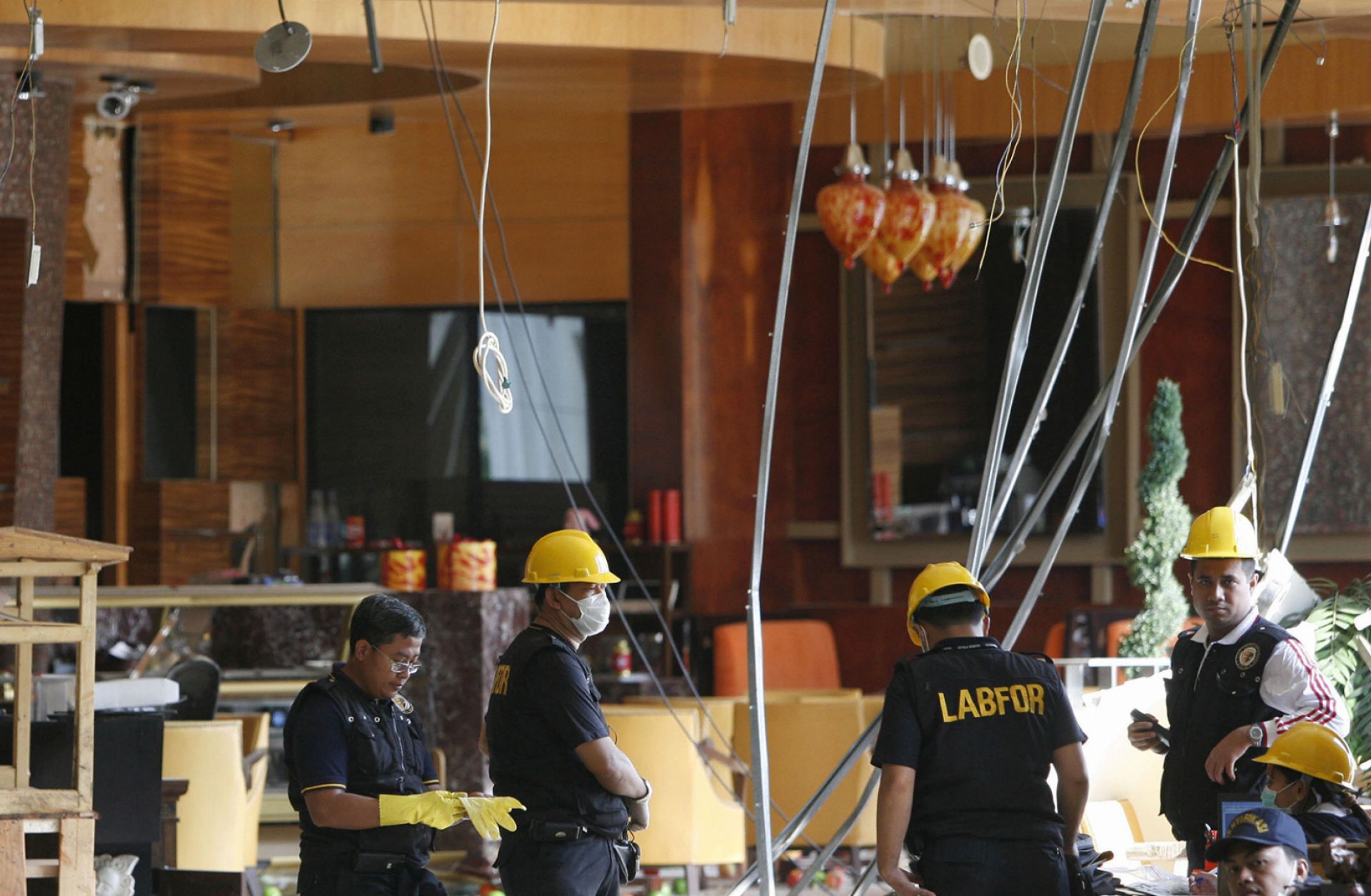 Indonesian forensic investigators scour the site of a bombing at the Ritz-Carlton hotel in Jakarta on July 18, 2009. An employee of a shop in the hotel facilitated the attack.