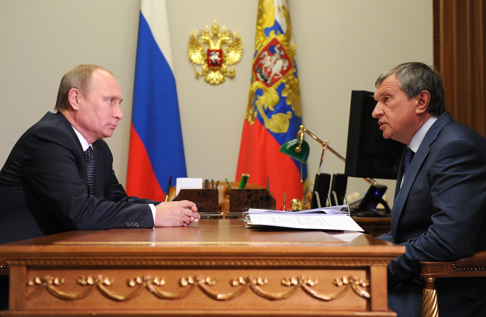 Russian President Vladimir Putin and Igor Sechin (R), CEO of state-controlled Russian oil giant Rosneft, may be at odds in debates over proposals to make state firms pay more funds to the government.