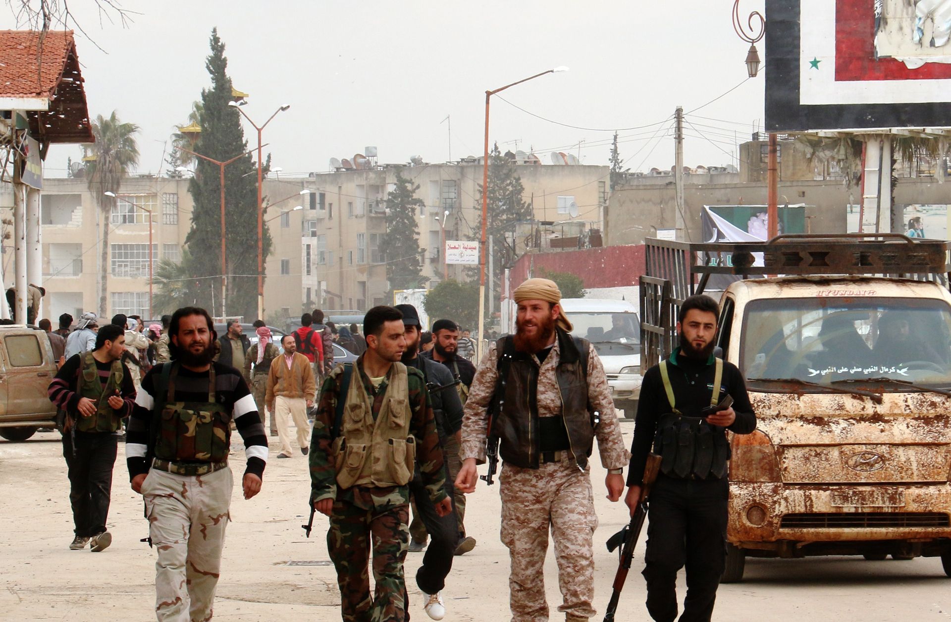 Fighters from a coalition of Islamist forces walk through the Syrian city of Idlib on March 29.