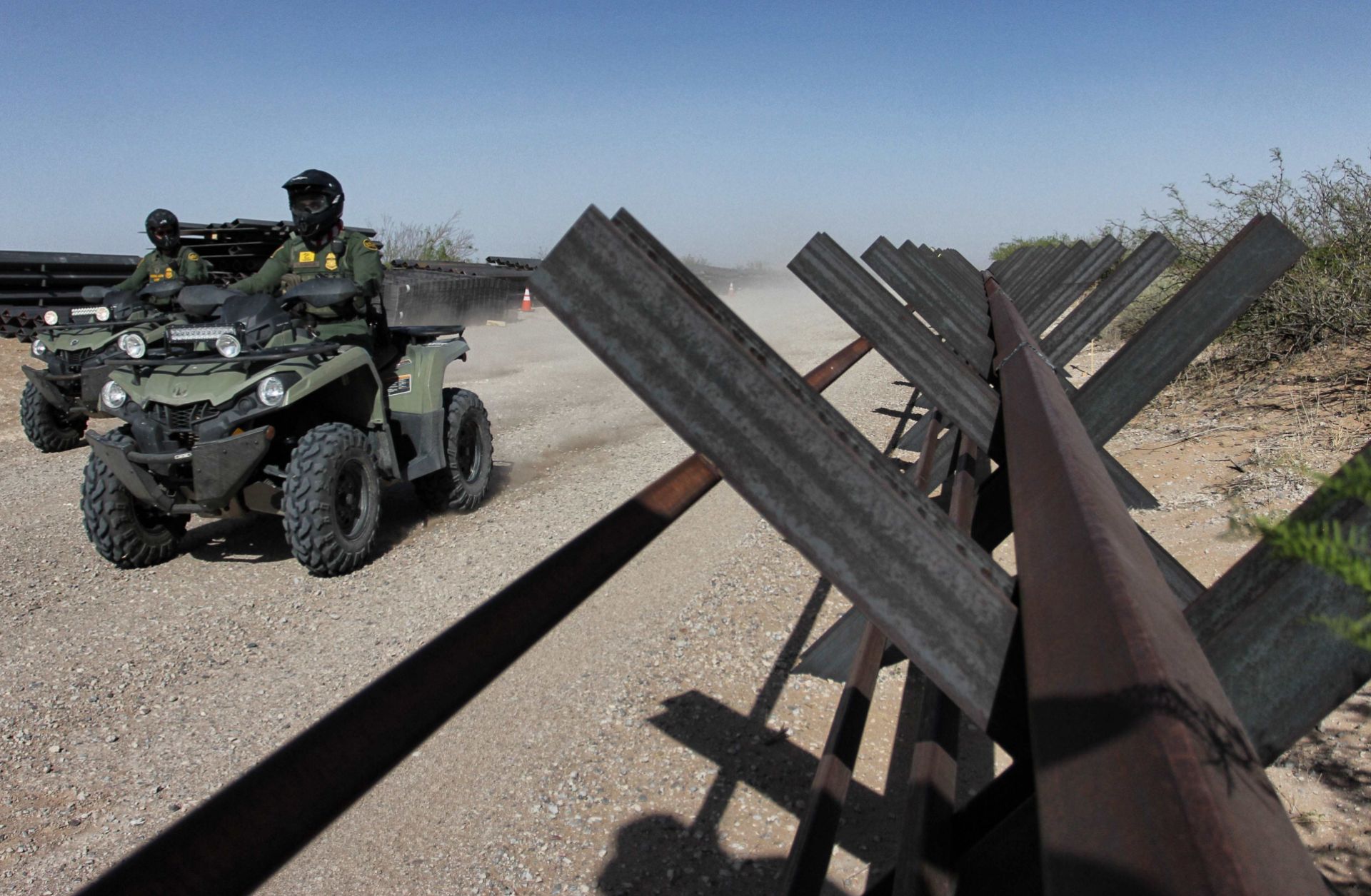 U.S. Border Patrol agents ride ATVs alongside an unfinished portion of a border wall between Ciudad Juarez in Mexico and Santa Teresa in the United States on April 17, 2018.