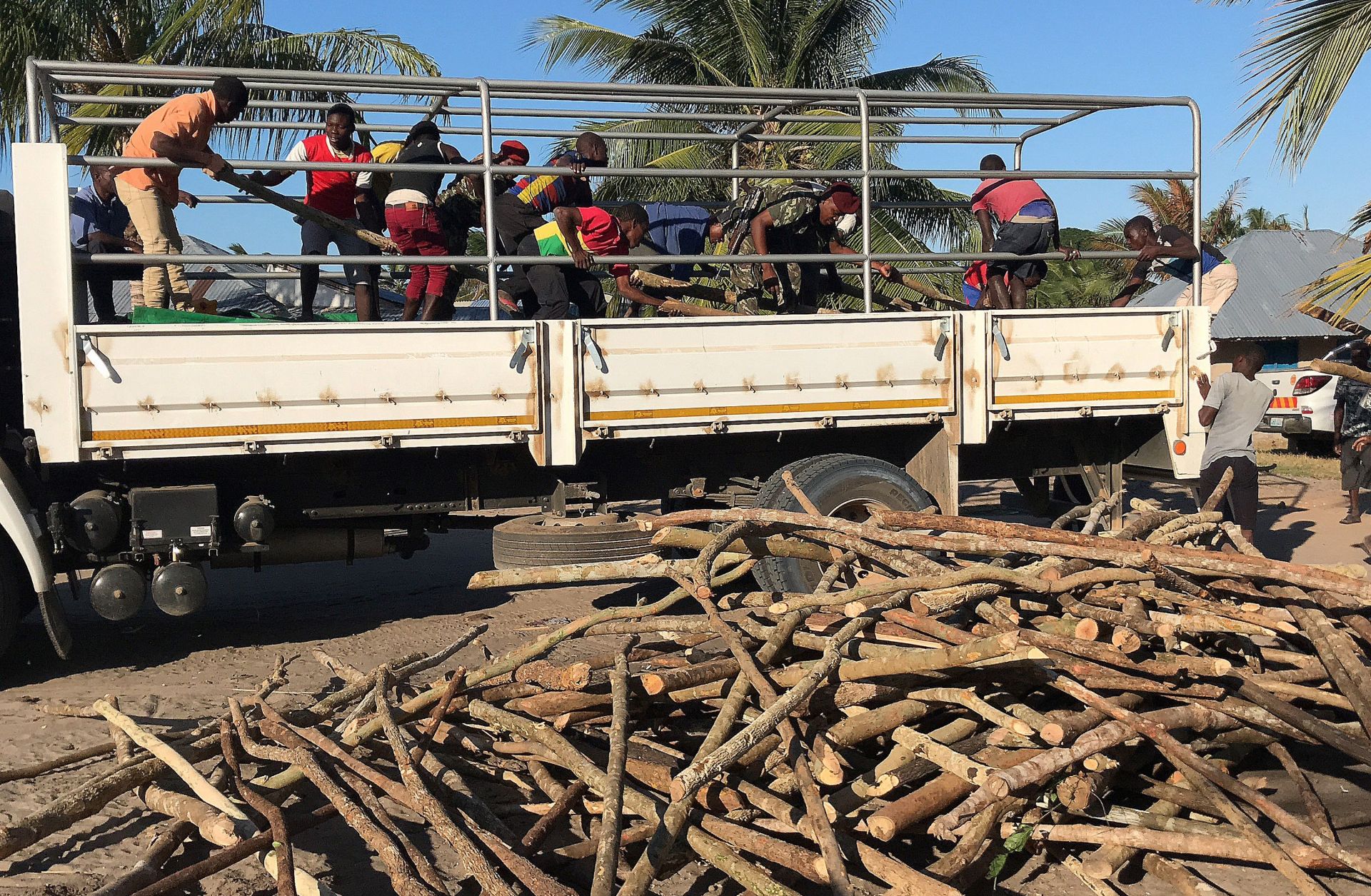 A picture shows internally displaced people and residents unload a truck with goods of first necessity, food and blankets in Naunde, northern Mozambique on June 13, after fleeing the recent attacks. 