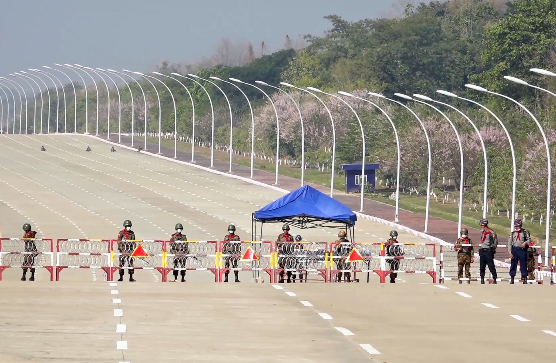 Soldiers stand guard on a blockaded road to Myanmar's parliament in Naypyidaw on Feb. 1, 2021, after the military detained the country's de facto leader and president in a coup. 
