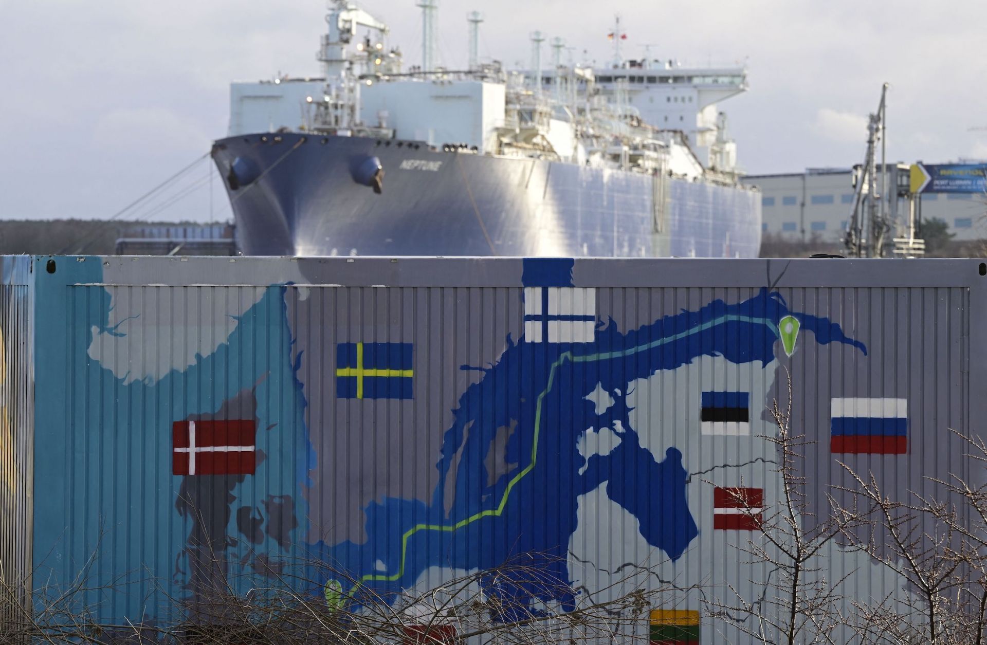 A floating storage and regasification unit (FSRU) is pictured behind a container painted with a map showing the Nord Stream 2 gas pipeline in Lubmin, northeastern Germany, on Jan. 14, 2023. 