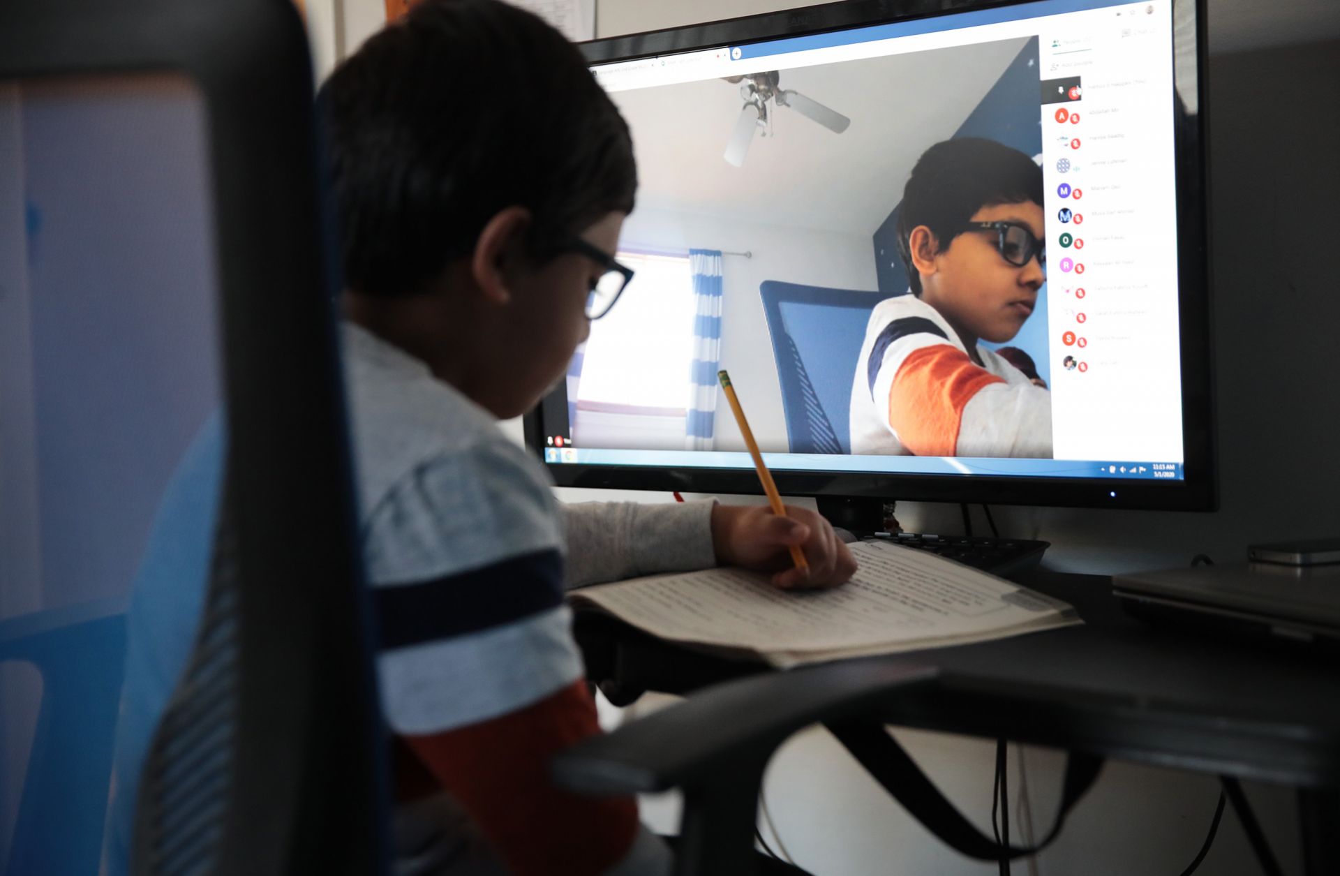 Seven-year-old Hamza Haqqani, a 2nd grade student at Al-Huda Academy, uses a computer to participate in an online class with his teacher and classmates at his home in Bartlett, Illinois, on May 1, 2020. Al-Huda Academy has had to adopt an e-learning program to finish the year after all schools in the state were forced to cancel classes to curb the spread of COVID-19. 