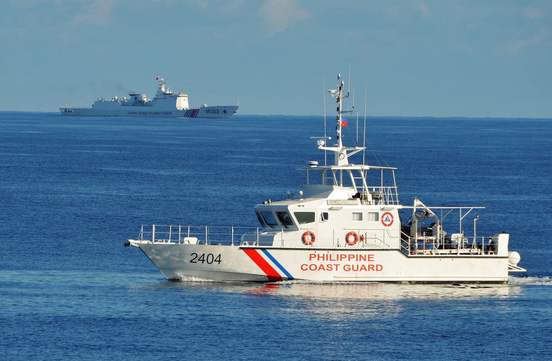 Philippine and Chinese coast guard ships sail past each other in the South China Sea on May 14, 2019. 