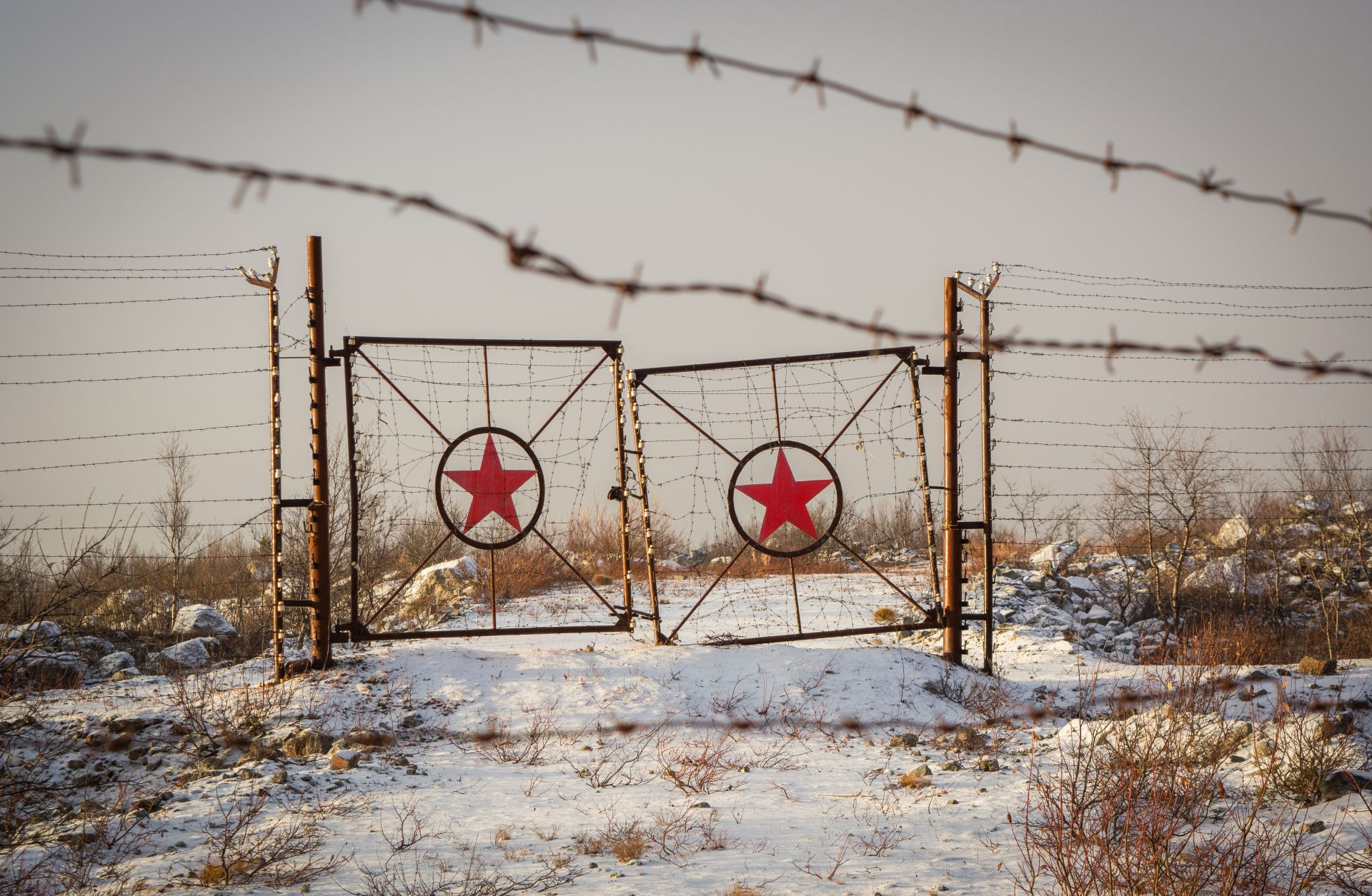 A picture of rusted gates with the star of the former Soviet Union on them. 