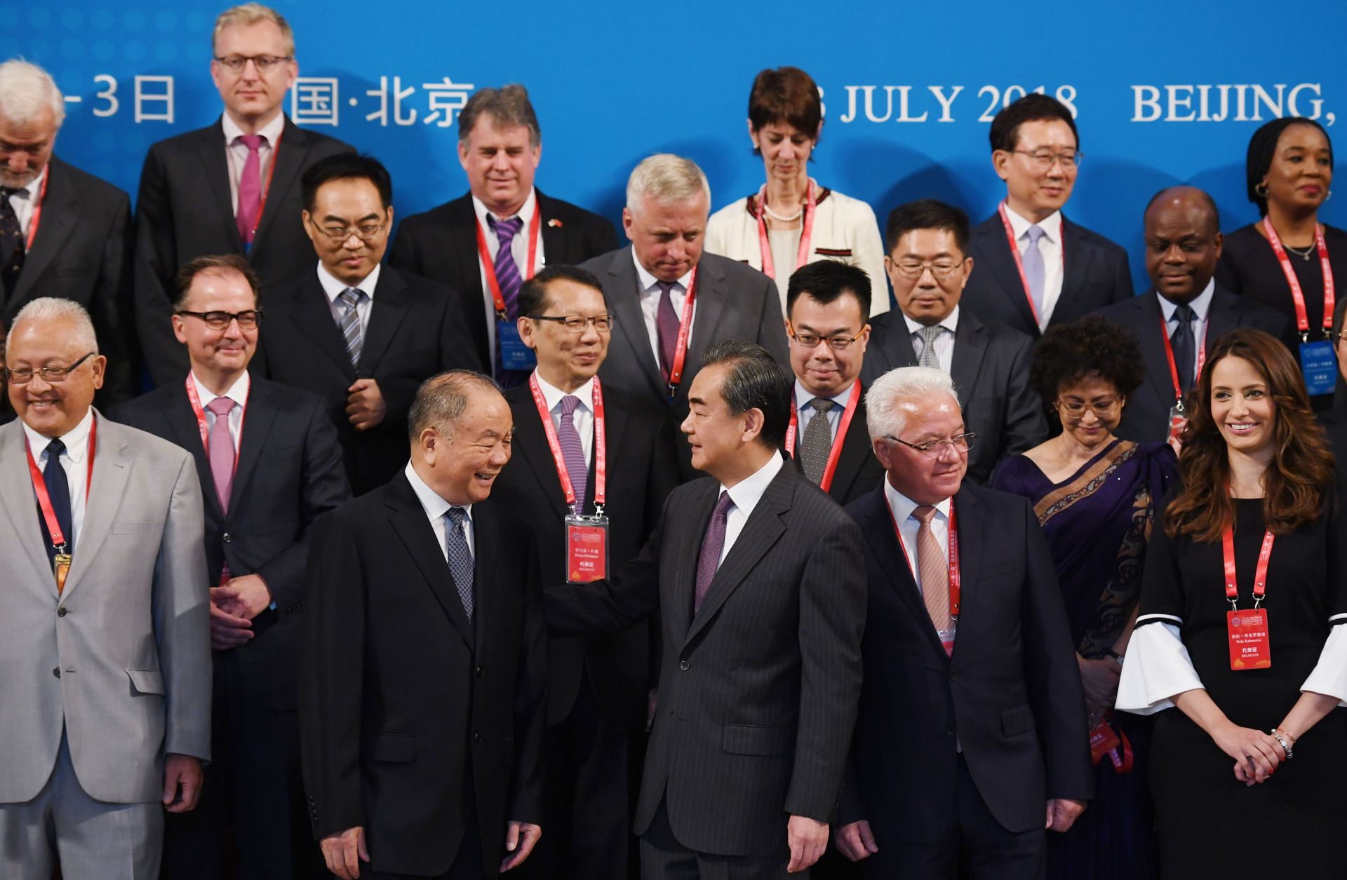 Chinese Foreign Minister Wang Yi, front center, stands with other delegates for a group photo before the Belt and Road Forum on Legal Cooperation began in Beijing on July 2, 2018.