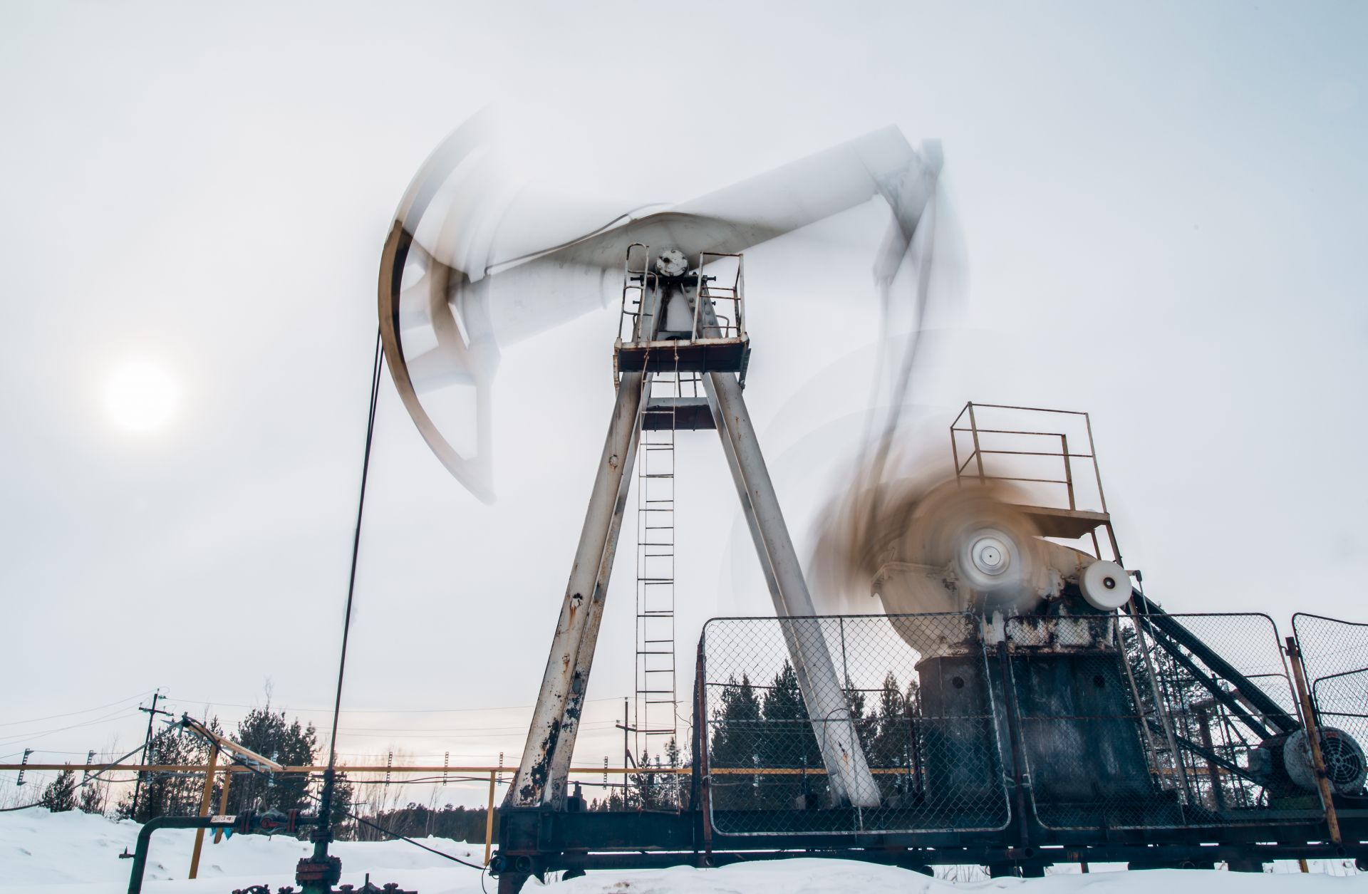 A photo of a pump jack extracting crude oil from a snow-covered well located near Surgut, Russia.