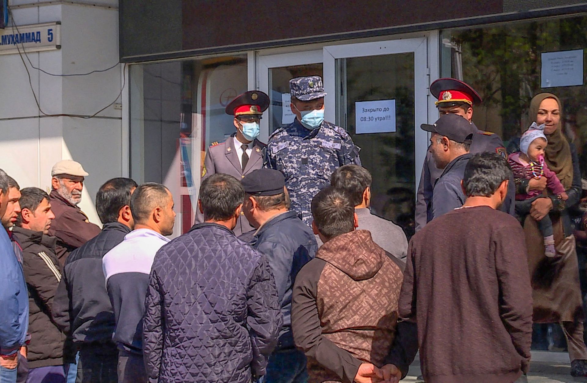 People seeking to return to work in Russia line up outside Tajikistan's state air ticket agency in the capital of Dushanbe on April 8, 2021. 