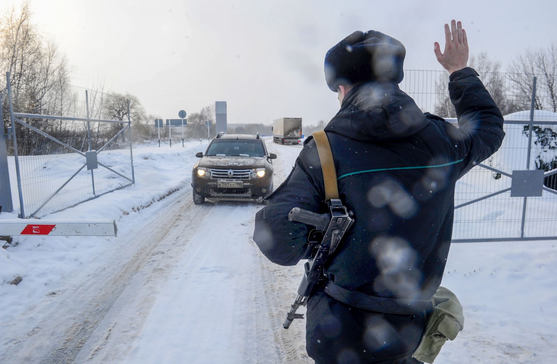 A guard stops a vehicle at Russia's Troyebortnoye border checkpoint on the Russian-Ukrainian border.