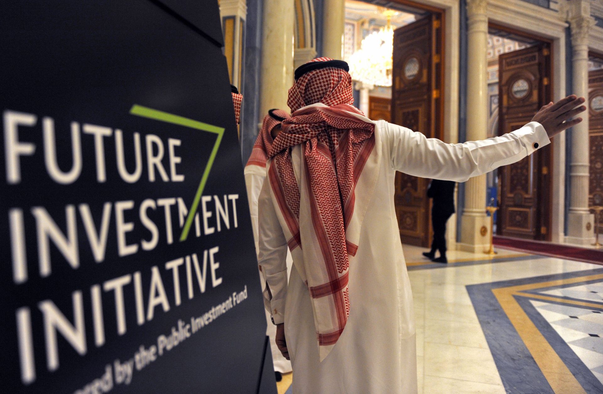 Saudi Arabia has plenty of cash, but it might not be enough to entice investors to park their money in the kingdom. A Saudi man gestures near a sign at the start of the three-day Future Investment Initiative in Riyadh on Oct. 23, 2018.