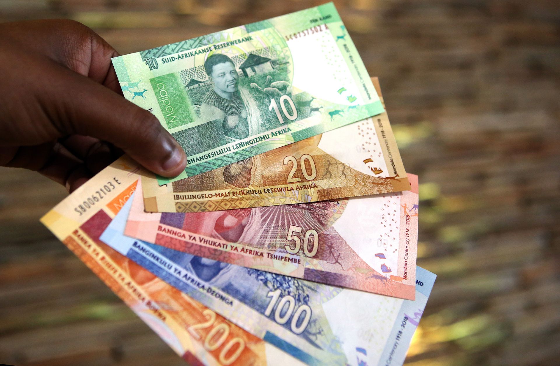 A man holds new South African banknotes of the South African rand on July 13, 2018, in Pretoria, South Africa. A man holds new South African banknotes of the South African rand on July 13, 2018, in Pretoria, South Africa.