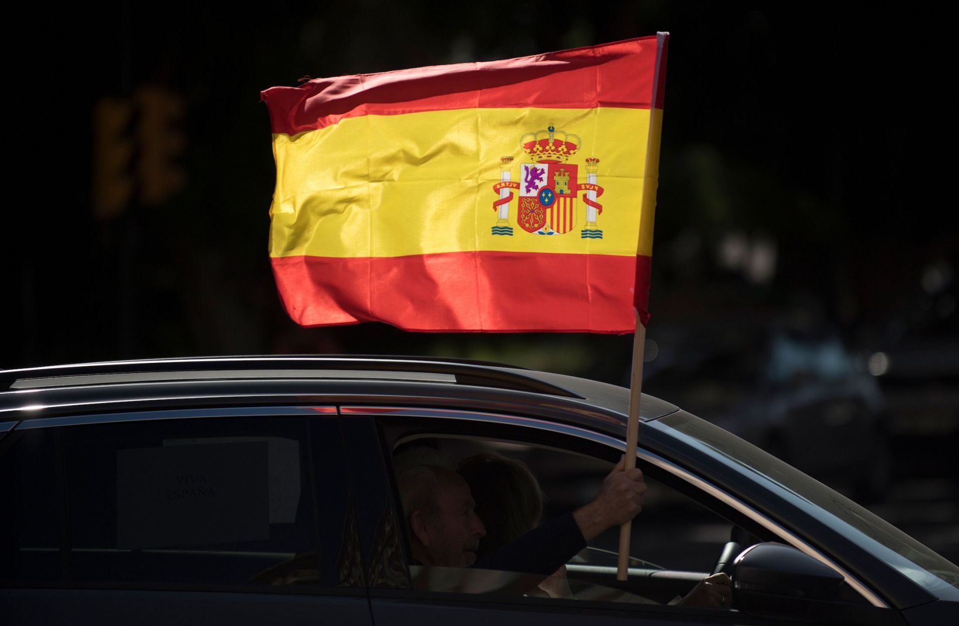 A driver waves a Spanish flag from his car during an anti-government demonstration organized by Spain's far-right Vox party in Malaga on Oct. 12, 2020. 