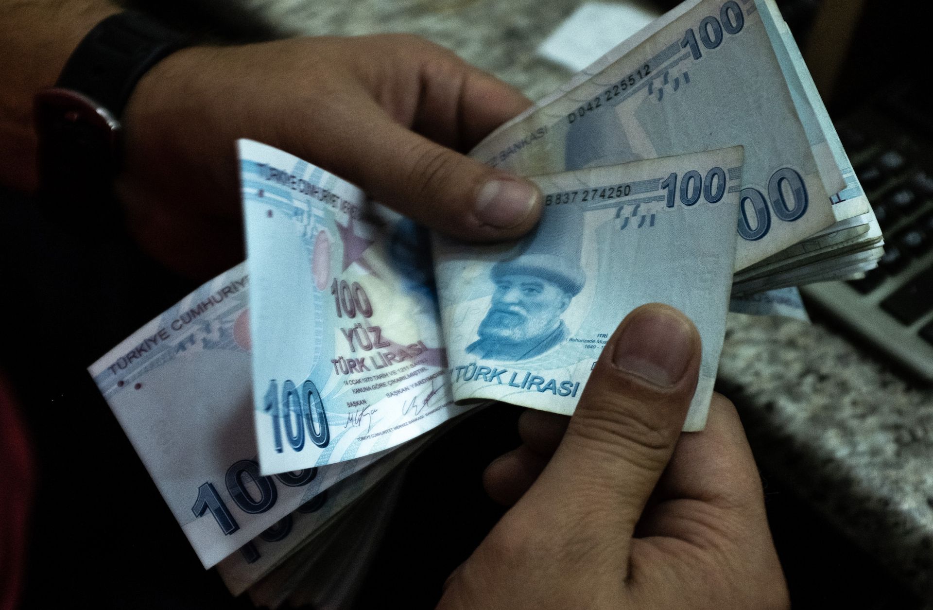 A man counts Turkish lira at a currency exchange office July 29, 2020, in Istanbul.