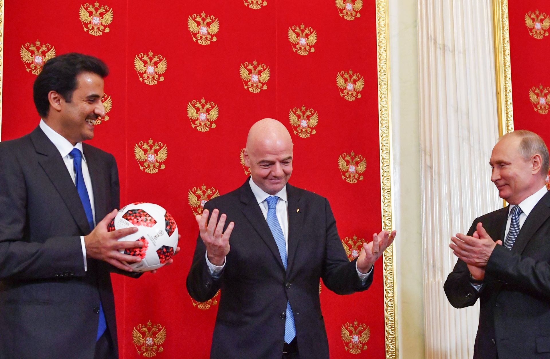 Qatari Emir Sheikh Tamim bin Hamad al-Thani (L) smiles at FIFA President Gianni Infantino (C) and Russian President Vladimir Putin at the end of the 2018 World Cup in Russia. As part of the closing ceremony, Putin passed a soccer ball to al-Thani, whose country will hold the next tournament in 2022, in a symbolic gesture.