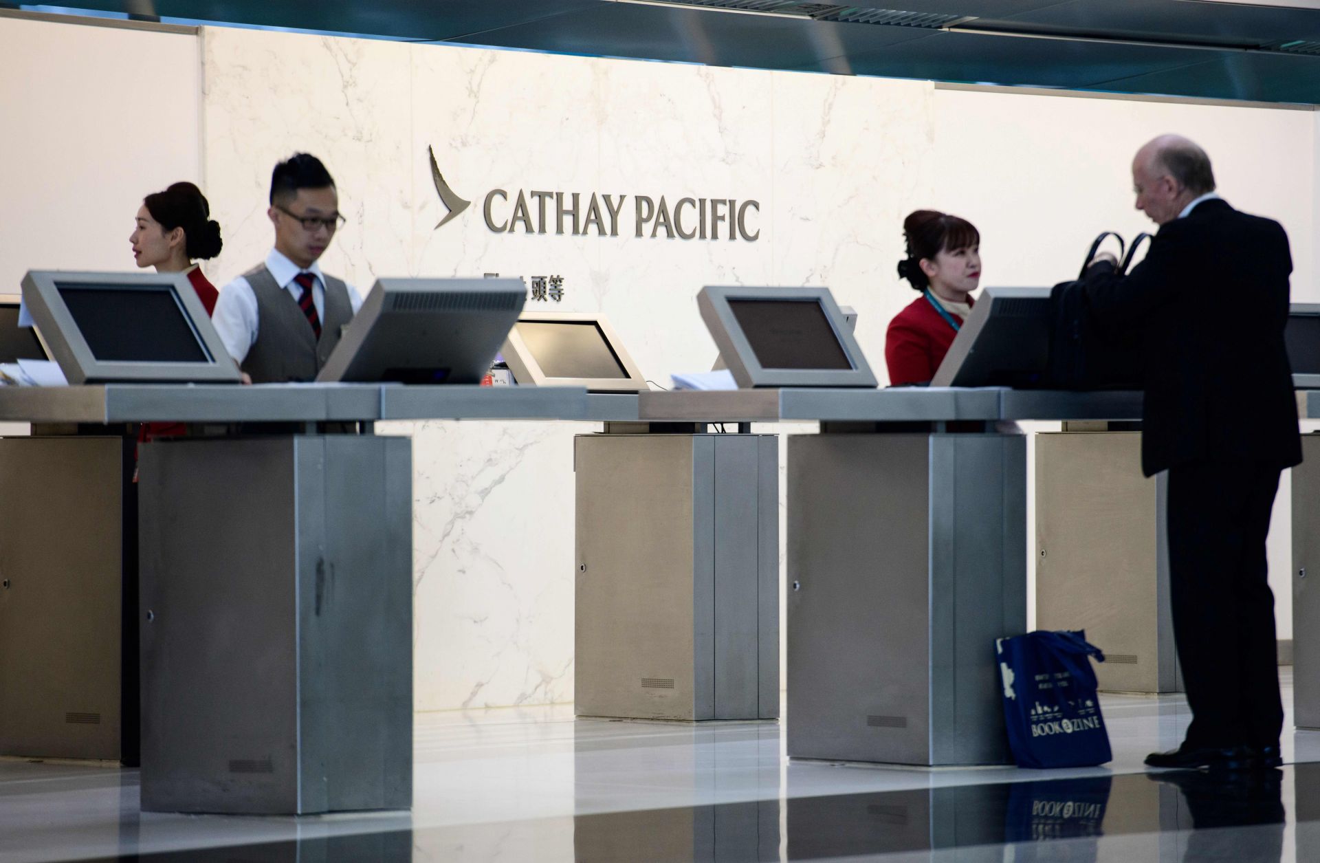 An employee of Cathay Pacific Airways helps a customer at Hong Kong's international airport on Aug. 7, 2018.