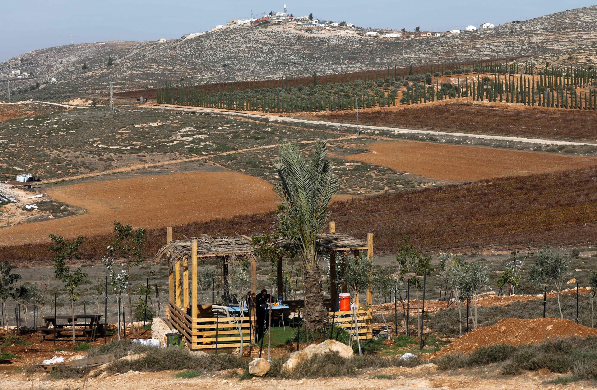 Settlers sit in a shack north of the Palestinian village of al-Mughayyir near the Israeli settlement of Shilo in the occupied West Bank on Nov. 20, 2018.