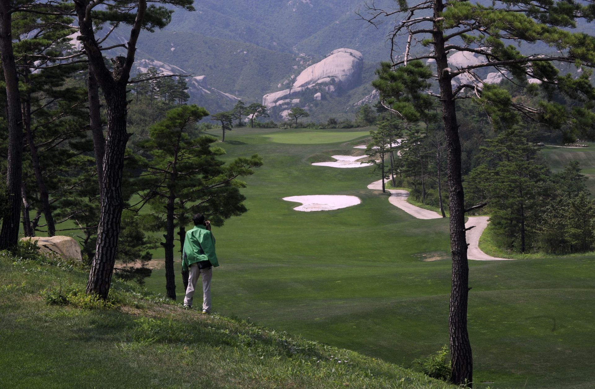 This photo shows a Chinese tourist photographing the derelict golf course at the shuttered Mount Kumgang resort in North Korea.