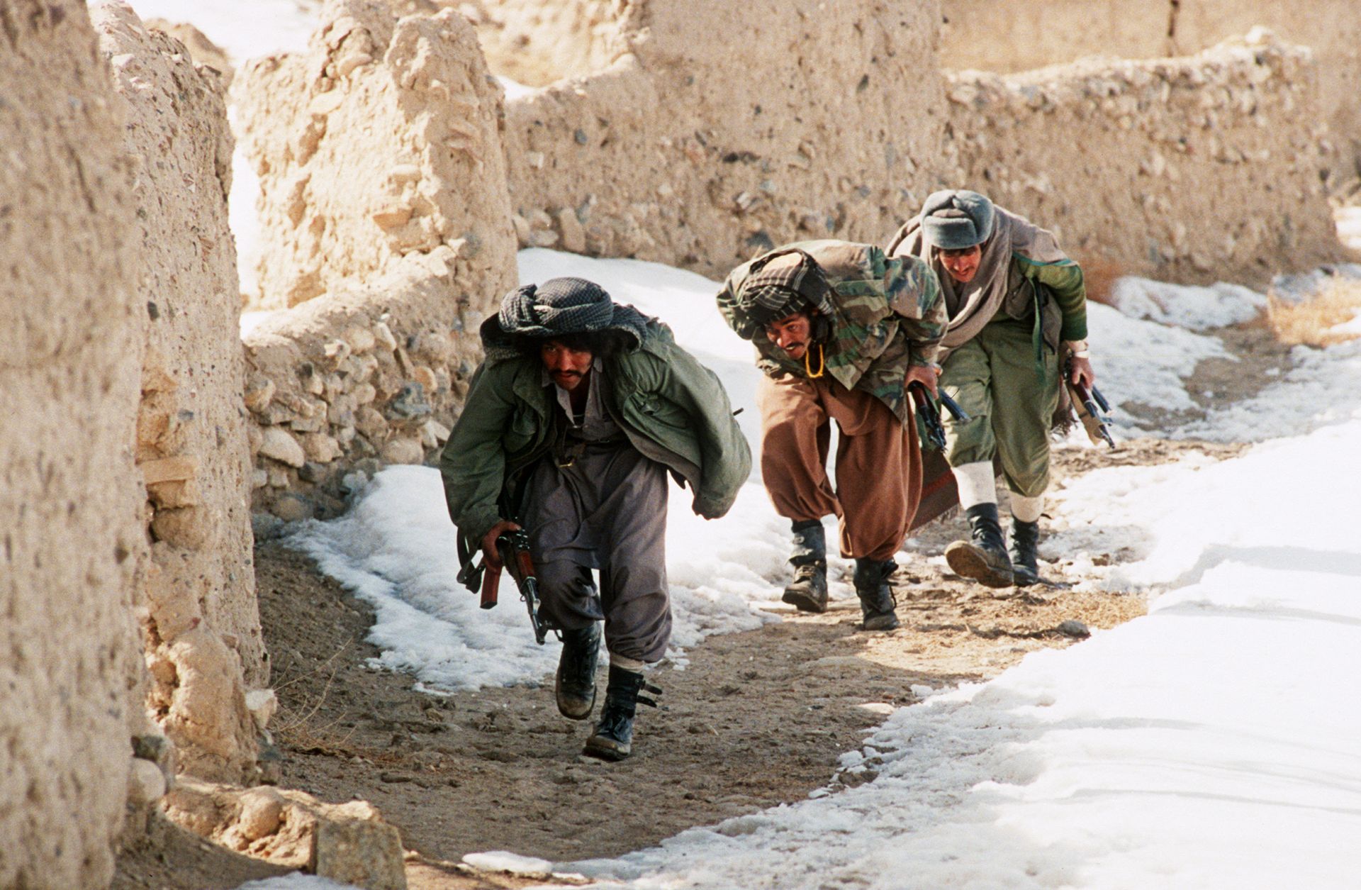 A group of Afghan mujahideen progress behind a wall in the village of Ghazni in southern Afghanistan as they fight Soviet-backed government forces in March 1989. A group of Afghan mujahideen progress behind a wall in the village of Ghazni in southern Afghanistan as they fight Soviet-backed government forces in March 1989.