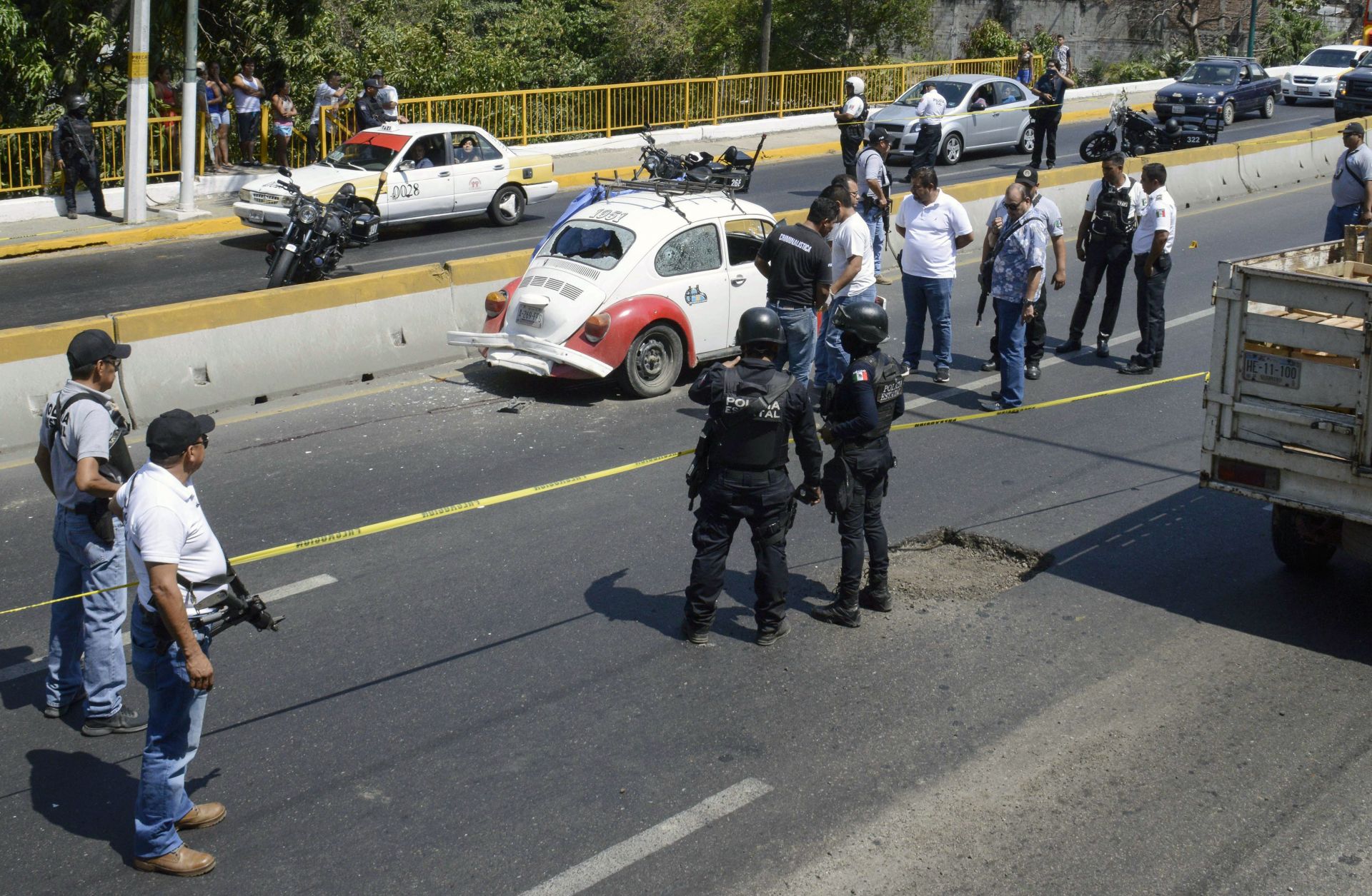 Authorities work at the scene where four racketeering suspects where shot down by security forces during a shoot-out along a highway in Acapulco in Guerrero on March 30, 2019.