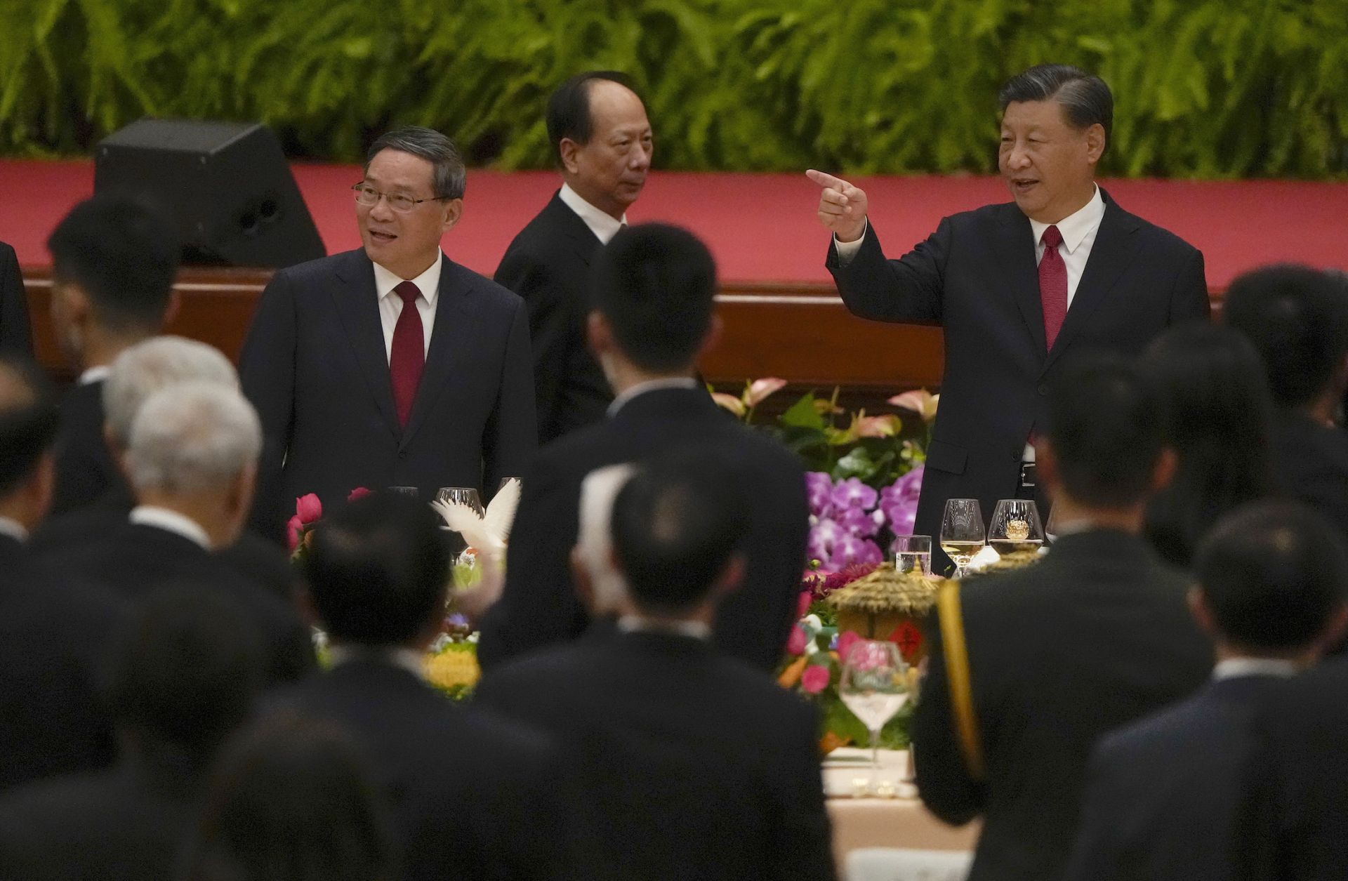 Chinese President Xi Jinping (right) gestures as he and his Premier Li Qiang (left) arrive for a dinner marking the 74th anniversary of the founding of the People's Republic of China on Sept. 28, 2023, in Beijing, China. 