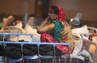 A patient rests at a banquet hall that’s been converted into a COVID-19 ward in New Delhi, India, on April 27, 2021. A patient rests at a banquet hall that’s been converted into a COVID-19 ward in New Delhi, India, on April 27, 2021.