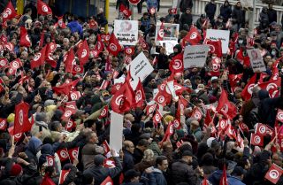 Tunisian protesters raise national flags during a demonstration against their president in the capital of Tunis on March 20, 2022. Tunisian protesters raise national flags during a demonstration against their president in the capital of Tunis on March 20, 2022.