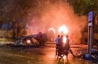 Flames engulf a vehicle belonging to the security personnel and a bus near outgoing Prime Minister Mahinda Rajapaksa's official residence in Colombo, Sri Lanka, May 9, 2022. 