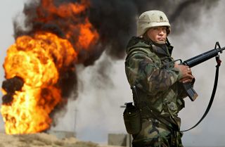 The United States sent troops into Iraq in 2003 to fight Saddam Hussein's government. U.S. forces returned to the country in 2014 to fight the Islamic State. More than 6,000 remain there today. U.S. Army Staff Sgt. Robert Dominguez stands guard next to a burning oil well in the oil fields of Rumaila, Iraq, on March 27, 2003.