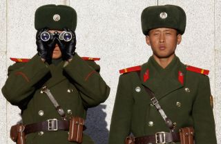 Soldiers in North Korea survey the South from across the Demilitarized Zone in late 2011.