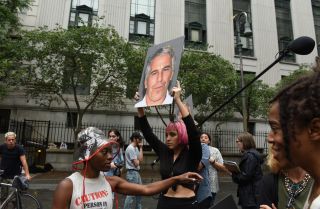 A protest group called Hot Mess holds up signs of Jeffrey Epstein at the federal courthouse in New York City on July 8, 2019.
