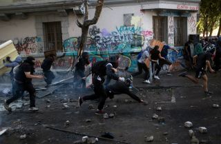 This photo shows protesters in Santiago, Chile, running from riot police on Nov. 19, 2019.