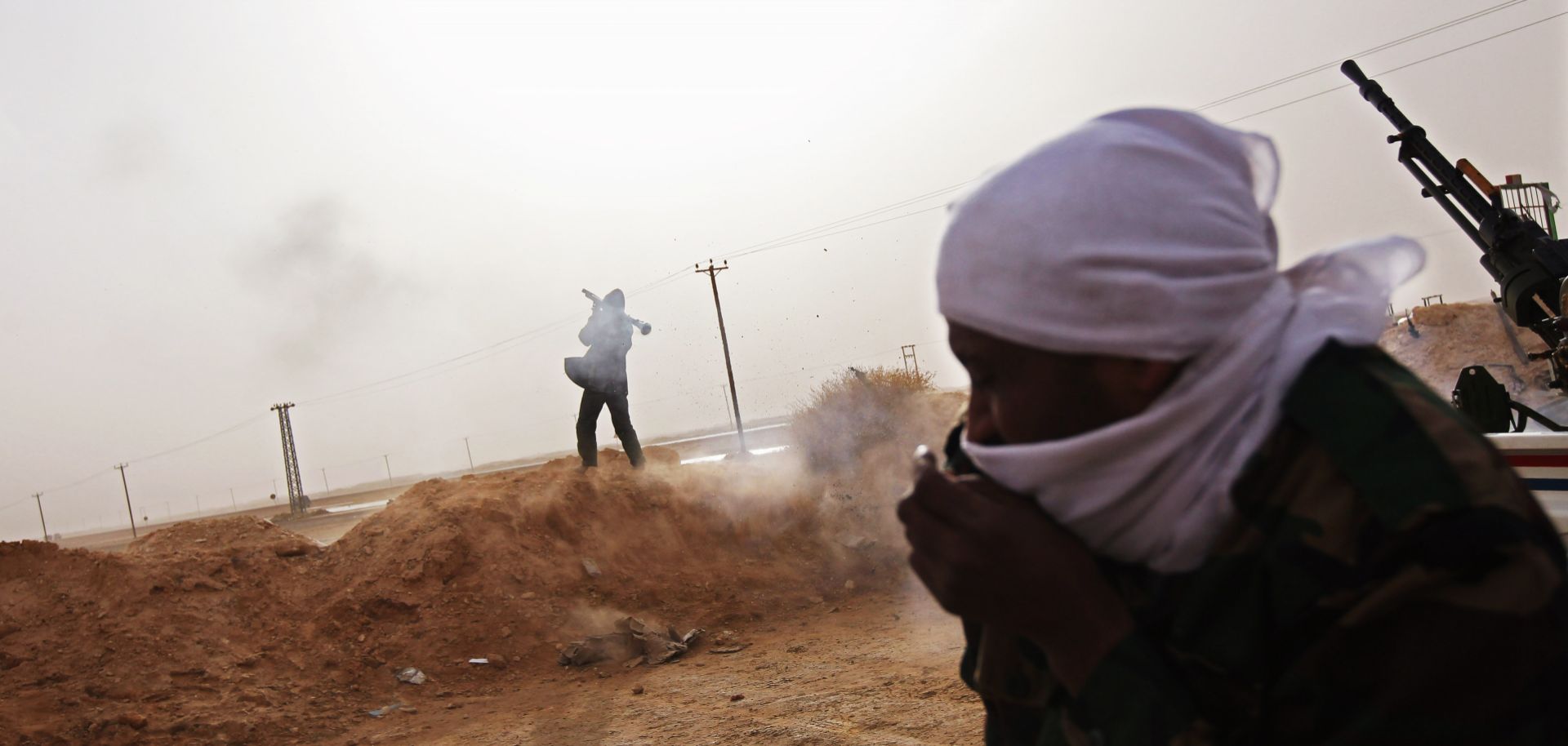 A tribal rebel fires a rocket propelled grenade from a militia post on February 27, 2011 in Ajdabiya, Libya.