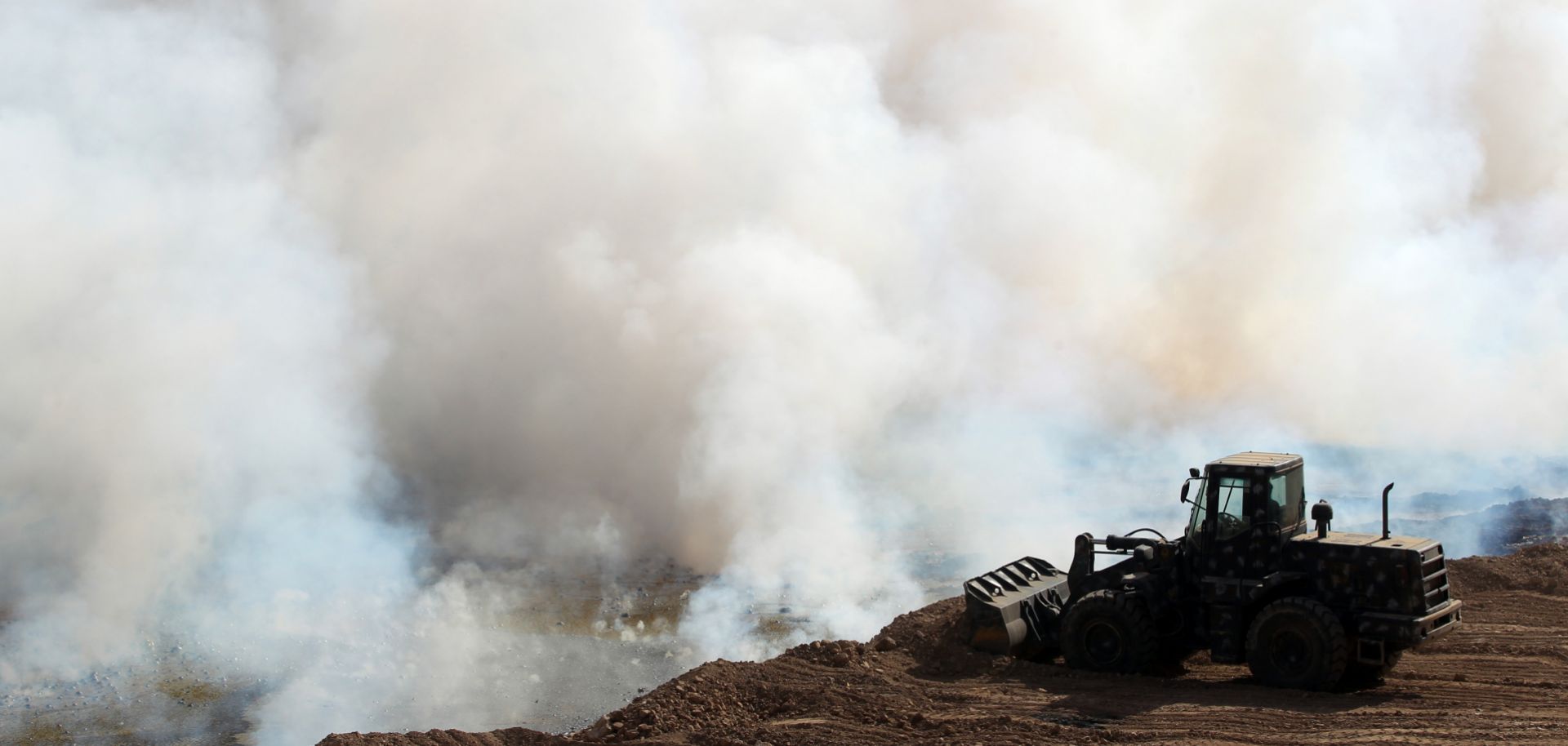 Iraqi forces attempt to extinguish a blaze set by the Islamic State in October 2016 south of Mosul.