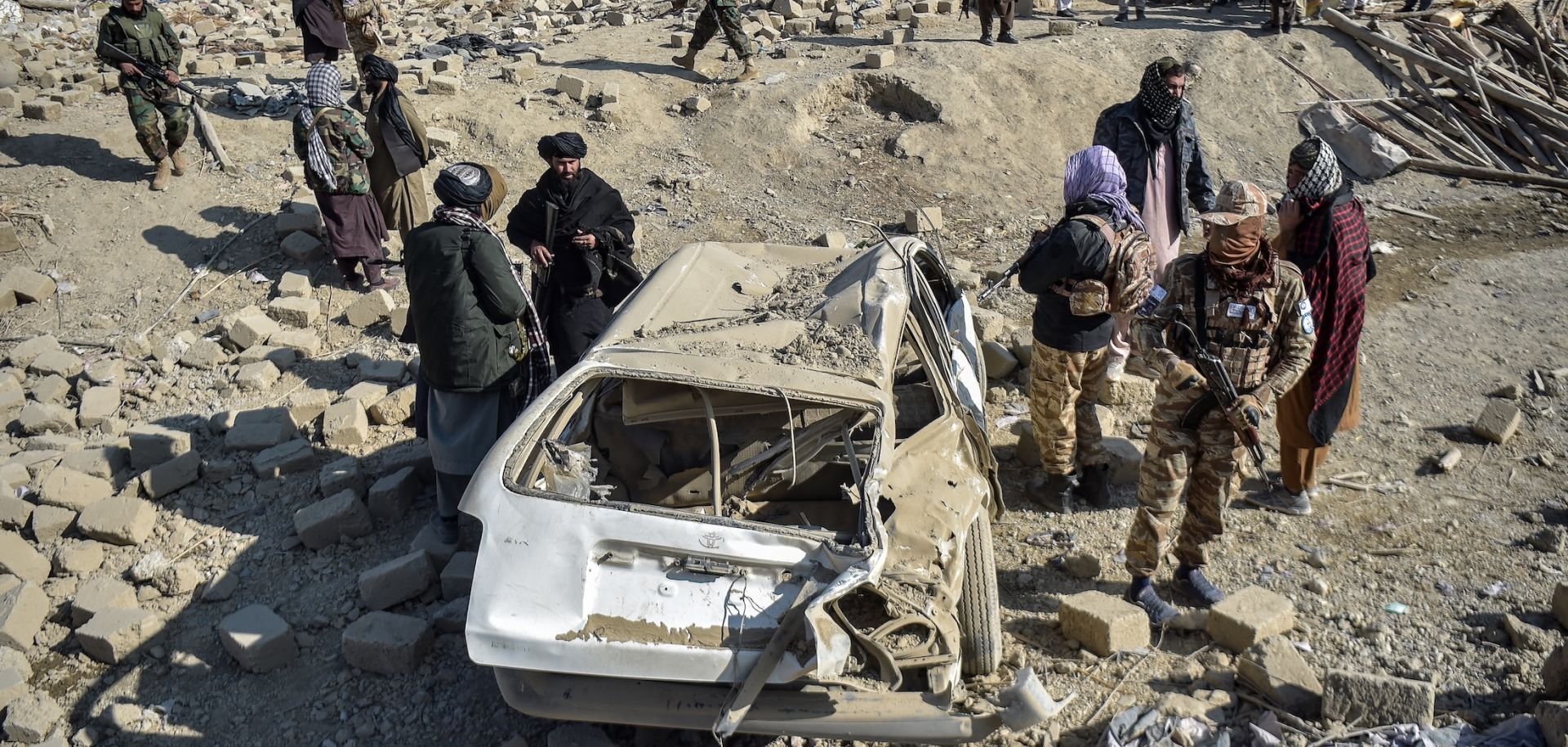 Taliban security personnel inspect a car damaged by Pakistani air strikes in Afghanistan's eastern Paktika province on Dec. 26, 2024. 