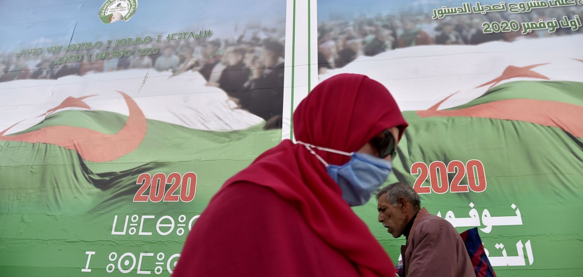 People walk past campaign billboards ahead of the upcoming constitutional referendum on a street in Algiers, Algeria, on Oct. 22, 2020. 