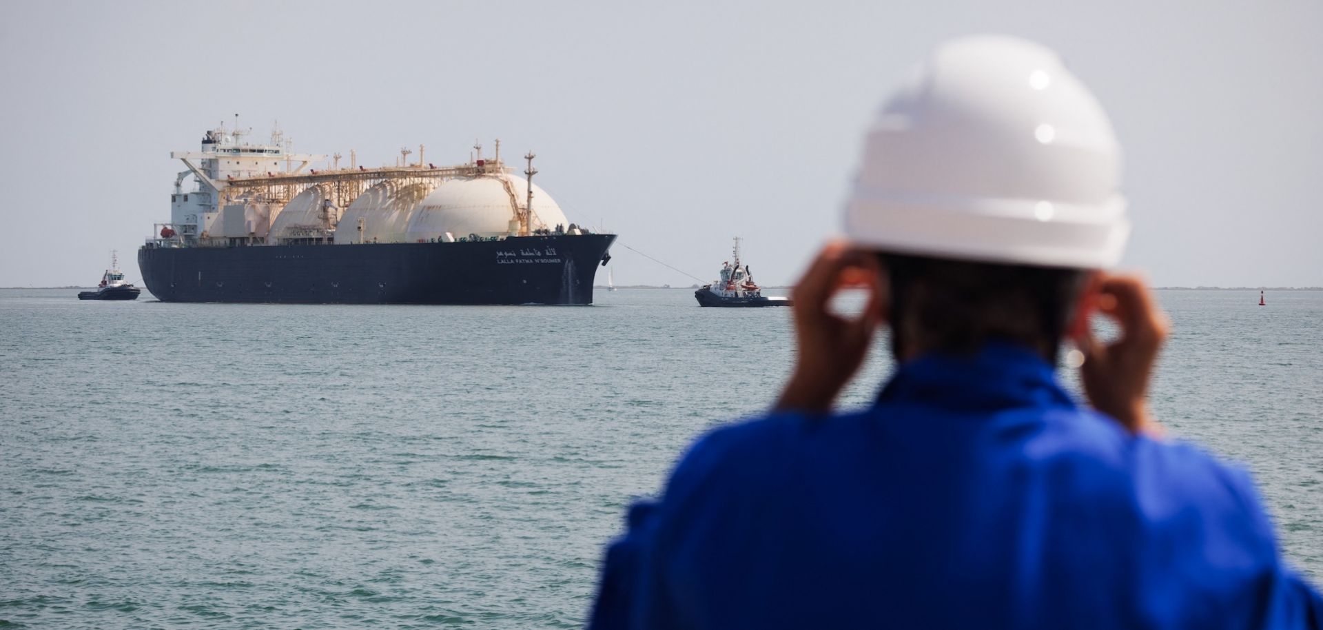 A worker stands on the uploading dock of Cavaou LNG terminal in Fos-sur-Mer, France, on June 22, 2023, while the tanker boat "Lalla Fatma N'Soumer" arrives full of LNG ready to be delivered. 