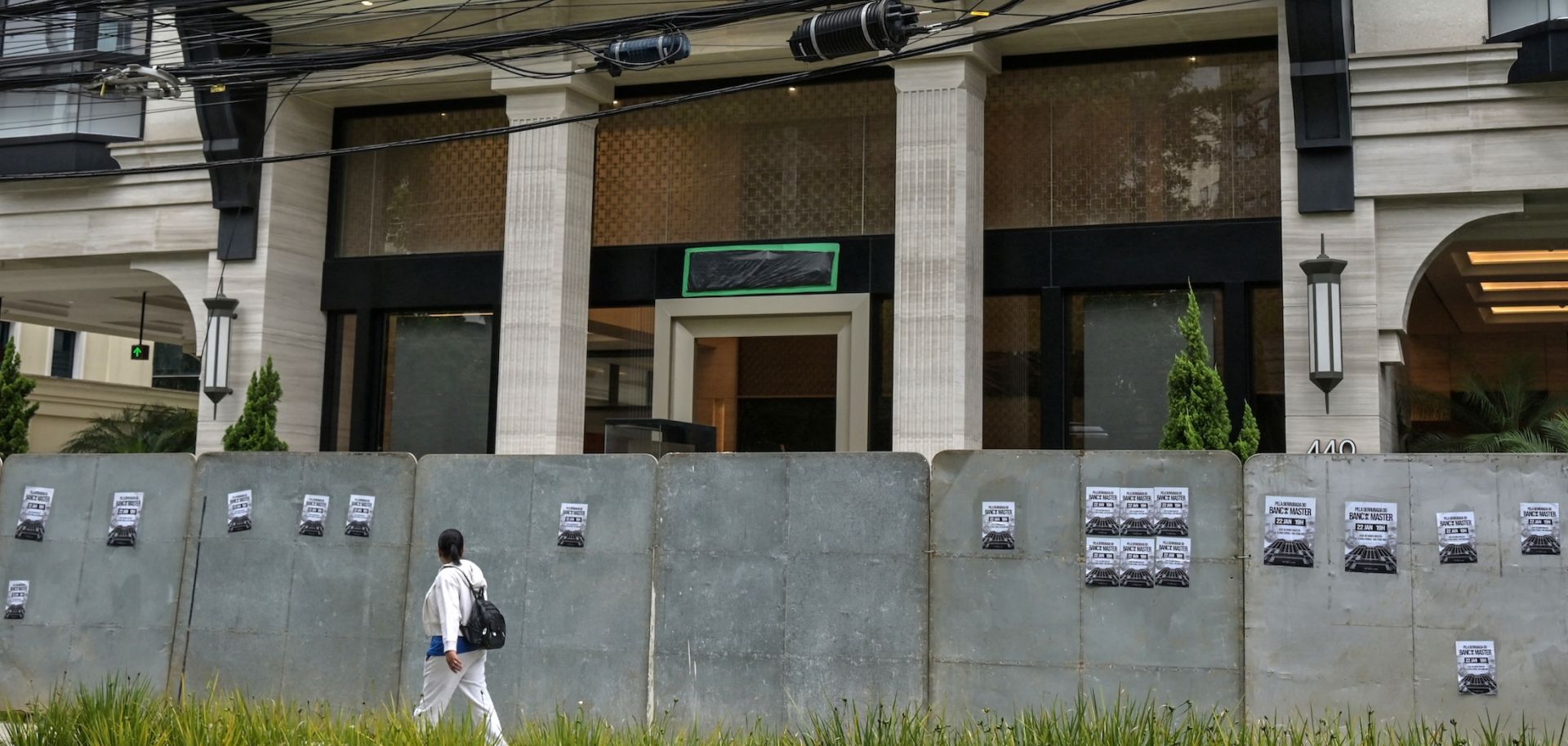 A passerby walks past the Banco Master building in Sao Paulo on Jan. 22, 2026, after Brazil's central bank ordered its shutdown due to a major liquidity crunch and "serious violations" of financial regulations.