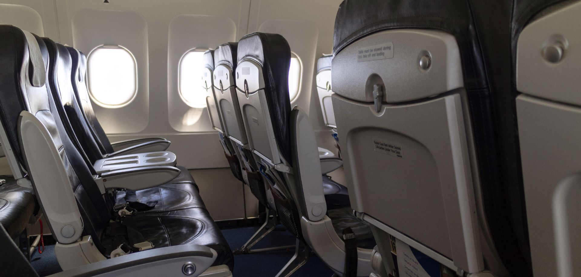 This photo shows a rows of seats on a passenger aircraft. 