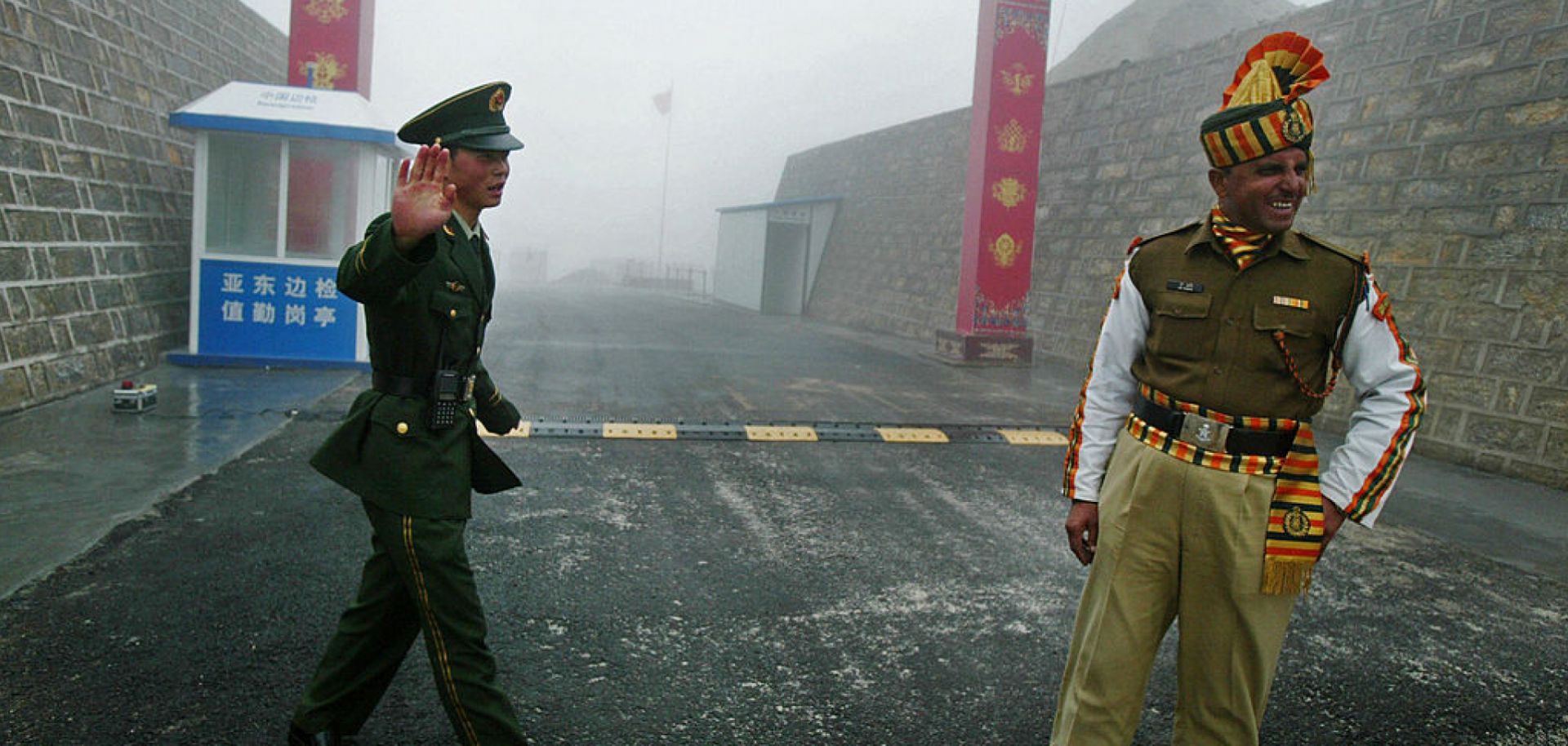 A Chinese soldier (L) and an Indian soldier (R) stand guard at the Chinese side of the ancient Nathu La border crossing between India and China.
