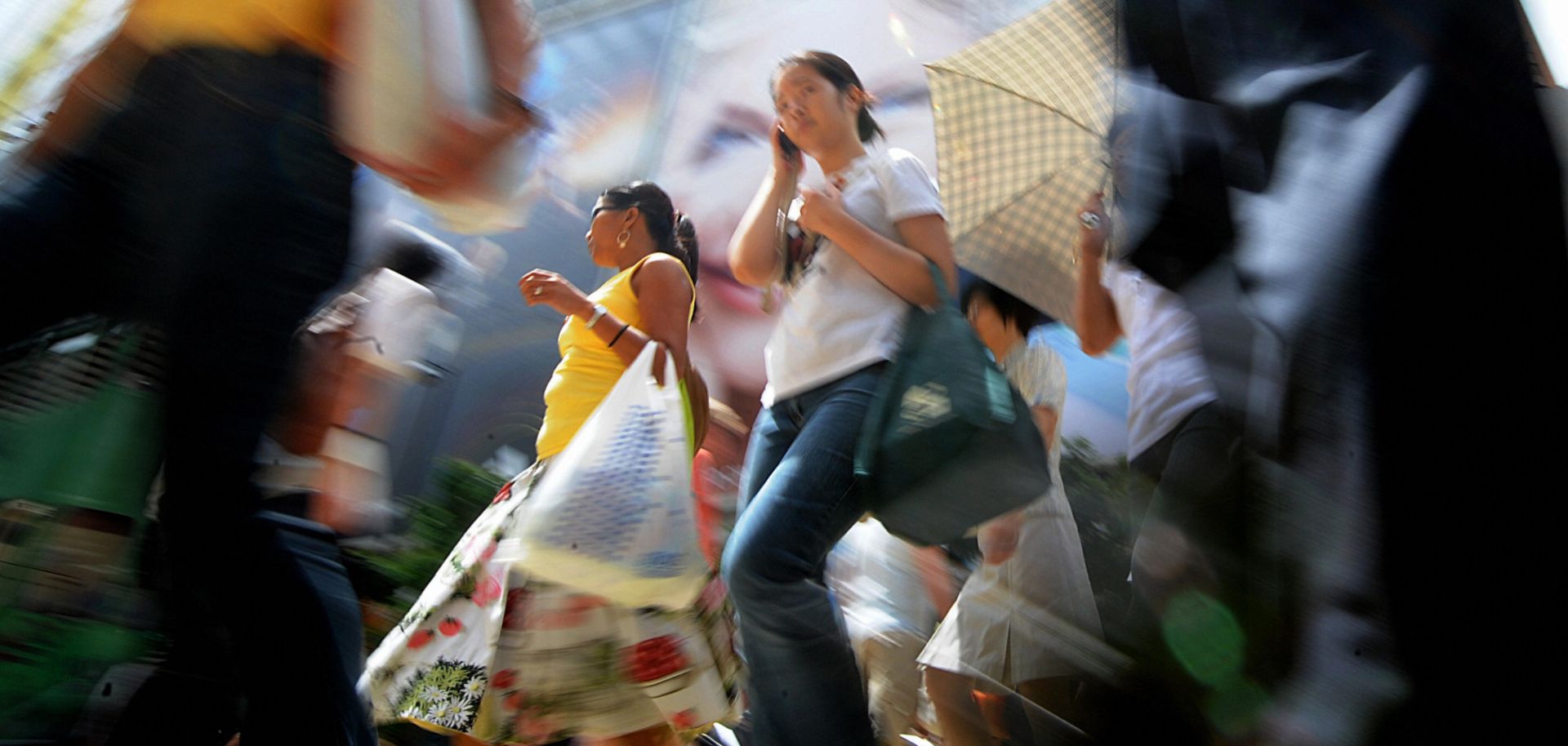 Shoppers cross the street in a busy retail area in Hong Kong on July 2, 2009. 