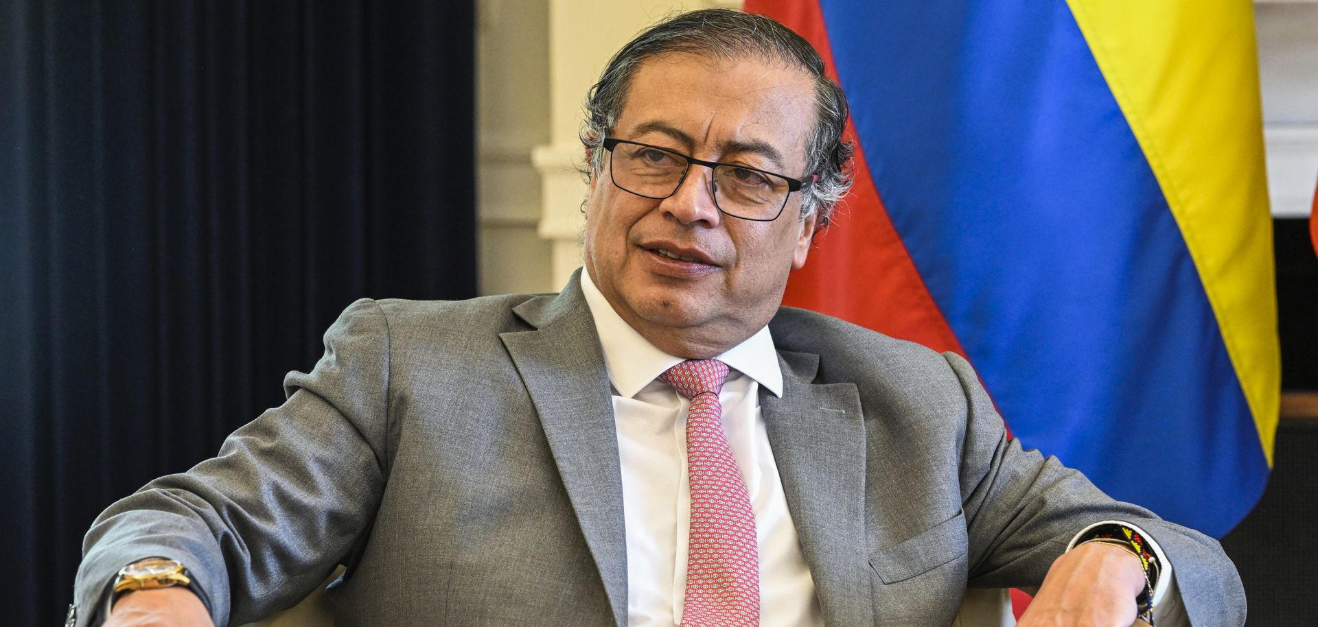 Colombian President Gustavo Petro sits in front of a Colombian flag during a meeting in Lisbon, Portugal, on May 6, 2023. 