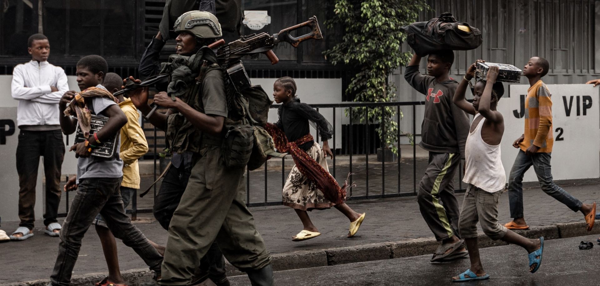 A member of the M23 armed group walks alongside residents through a neighborhood in Goma, eastern Congo, on Jan. 27, 2025. 