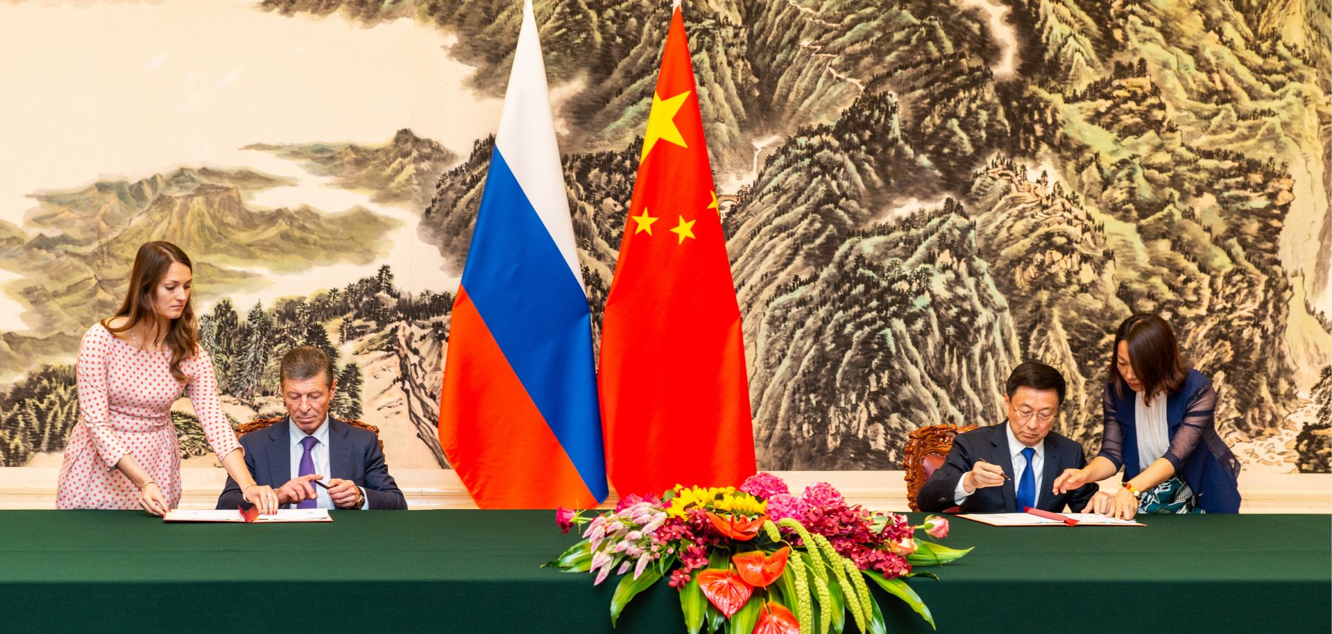 Russian Deputy Prime Minister Dmitry Kozak (seated, right) and Chinese Vice Premier Han Zheng (seated, left) sign joint documents following a meeting in Beijing on Sept. 6, 2019. Both officials are seated next to their countries respective national flags.