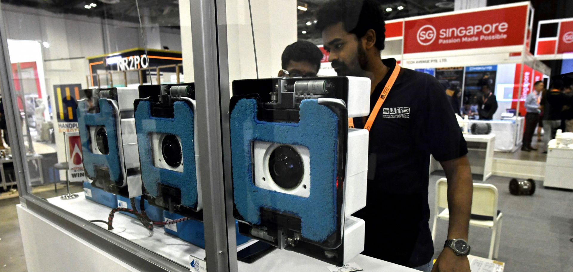 Representatives from Singapore University Technology and Design demonstrate prototype window-cleaning robots during an international exposition in November 2018.