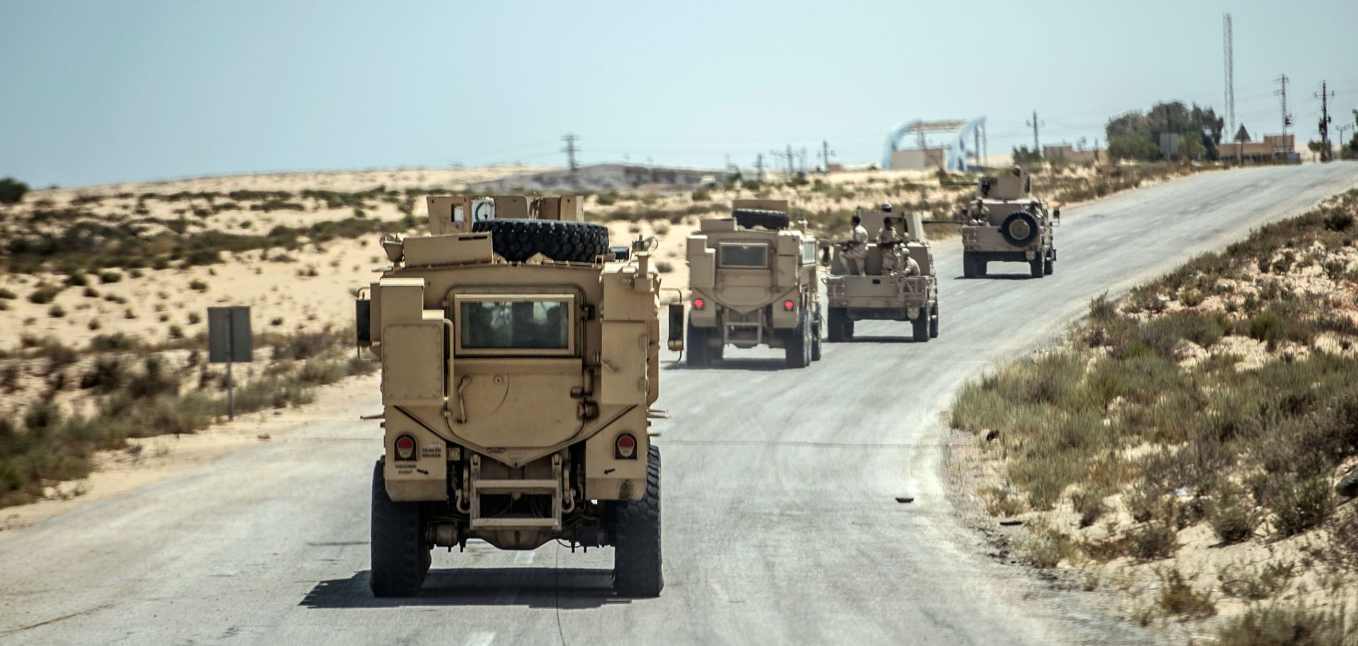 A picture taken on July 26, 2018 shows Egyptian policemen driving on a road leading to the North Sinai provincial capital of El-Arish.