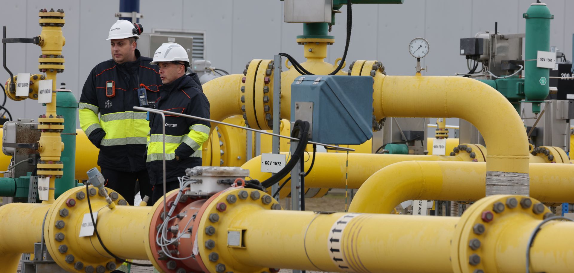 Workers at Polish natural gas company Gaz-System stand among pipes at a compressor station of the new Baltic Pipe natural gas pipeline on the day of its official opening on Sept. 27, 2022, near Goleniow, Poland.