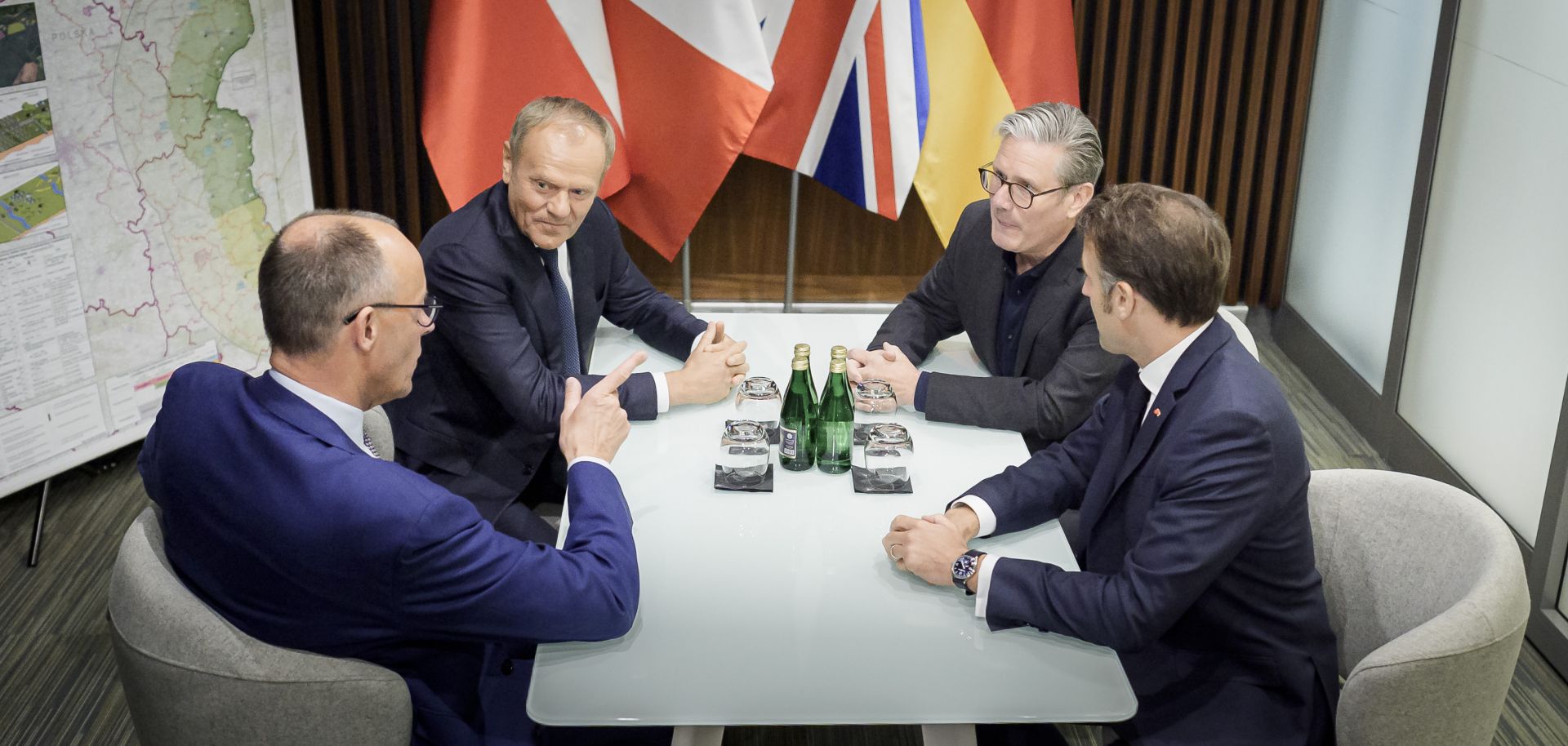 German Chancellor Friedrich Merz converses with Polish Prime Minister Donald Tusk, British Prime Minister Keir Starmer and French President Emmanuel Macron in a meeting room at the Rzeszow-Jasionka Airport before they travel to Ukraine on May 9, 2025, in Rzeszow, Poland.
